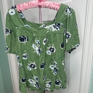 green short-sleeved top with a square neckline and a dark blue and white floral